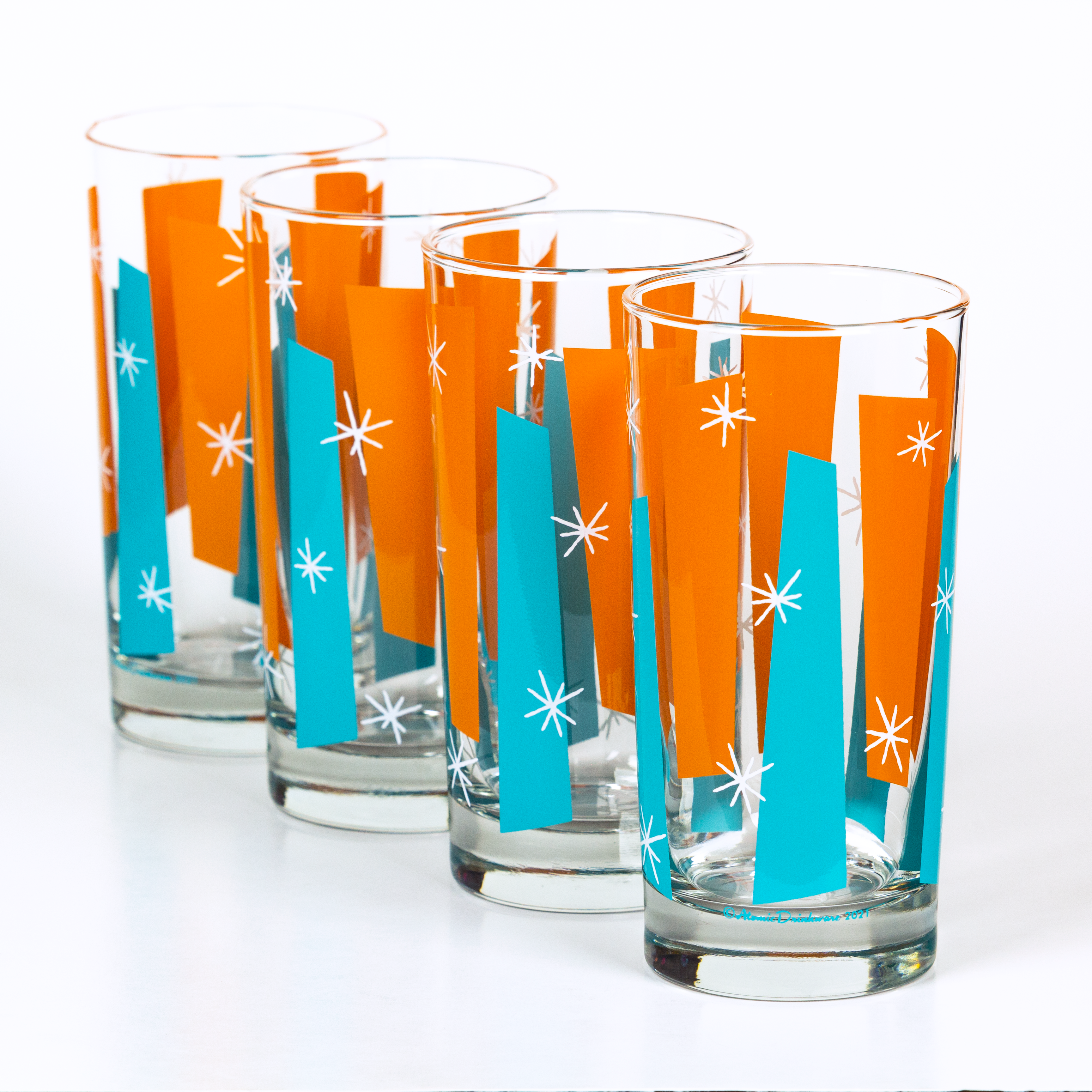 Set of four glass tumblers with orange and blue striped retro design on a white background