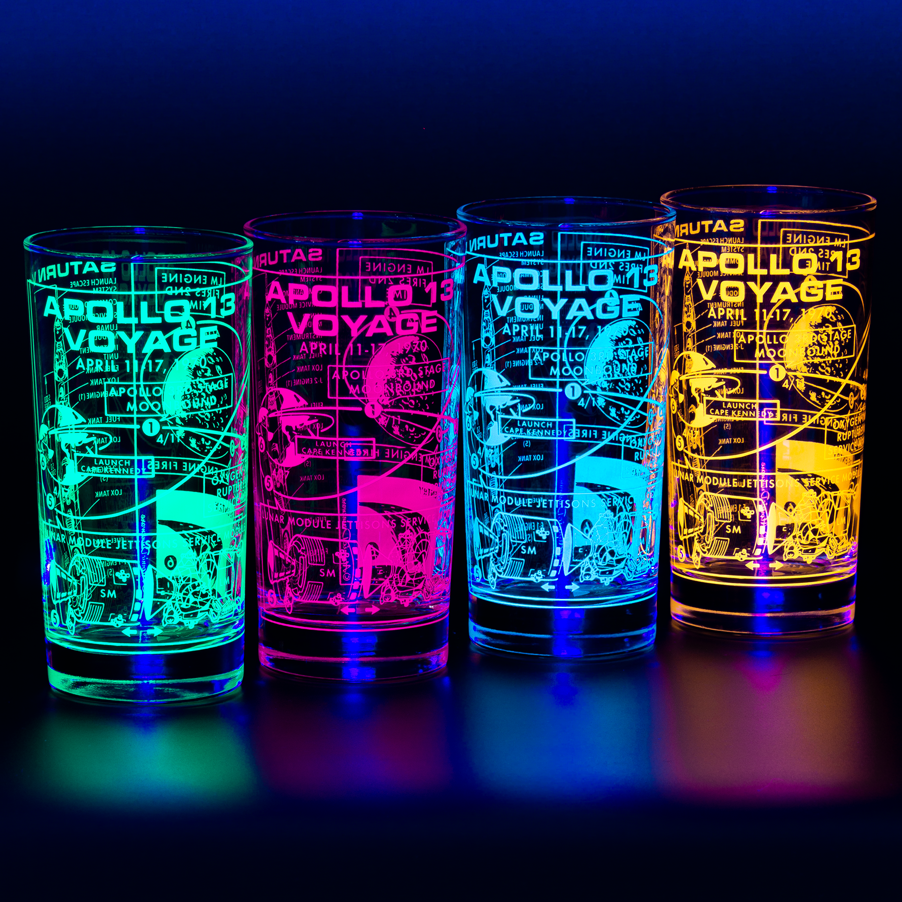 Four illuminated glasses with printed Apollo 13 and Saturn V space designs on a dark background