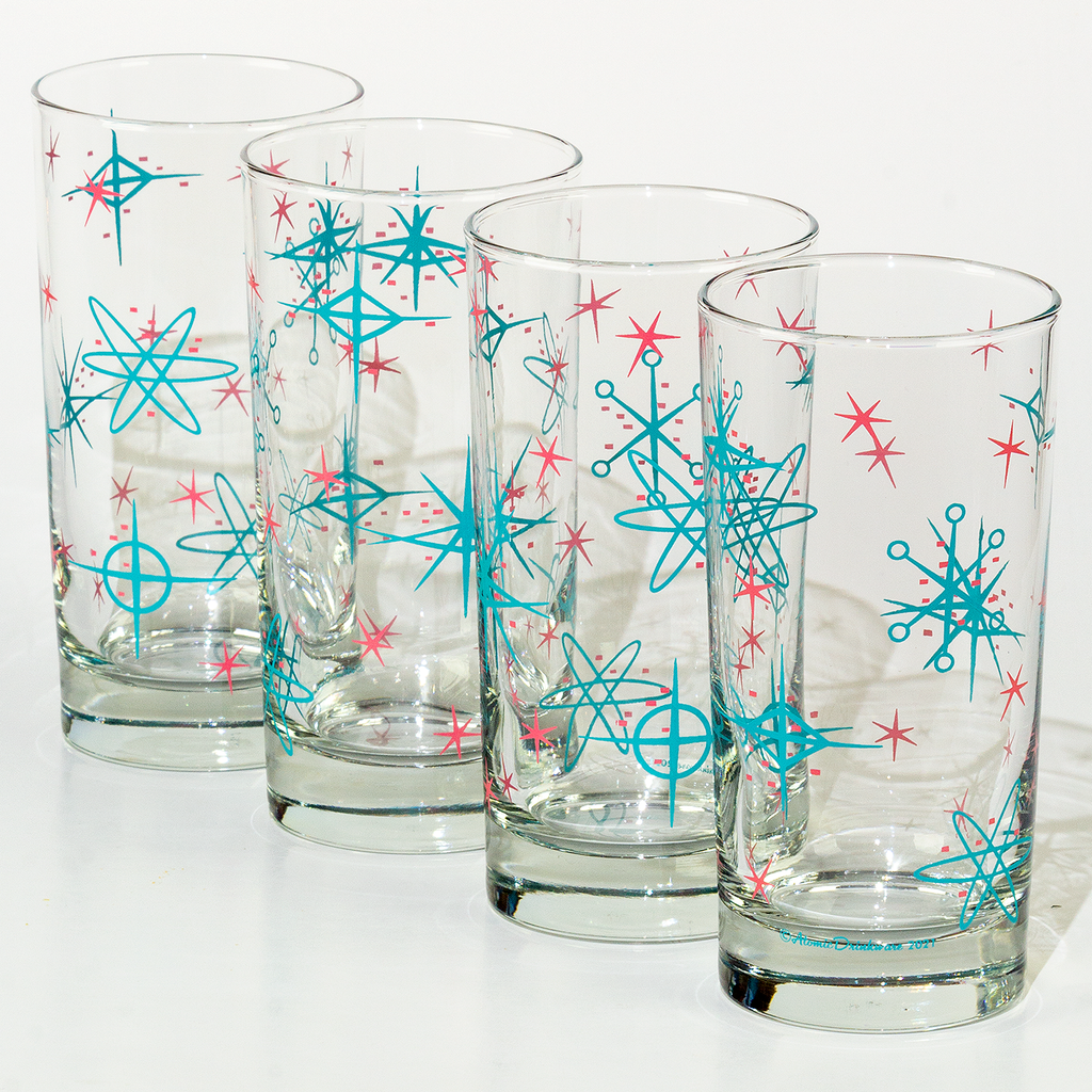 Four mid century modern glasses with blue and red atomic retro starburst patterns on a white background