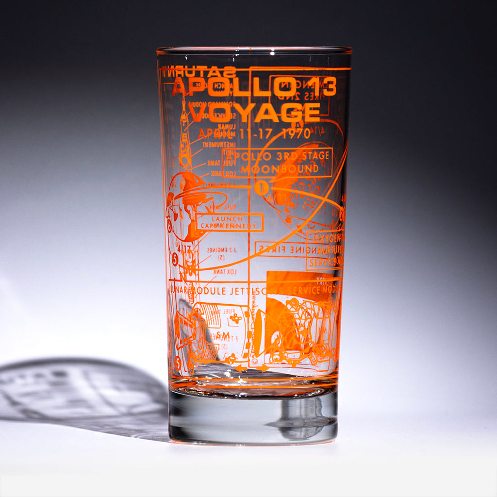 Glass with orange printed text and graphics on a gray background
