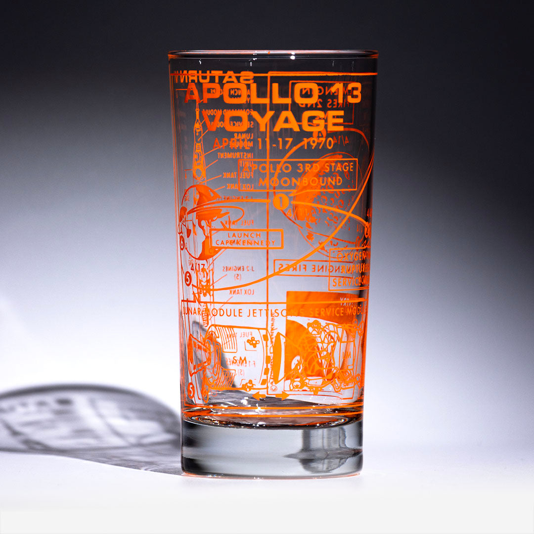 Glass with orange printed text and graphics on a gray background