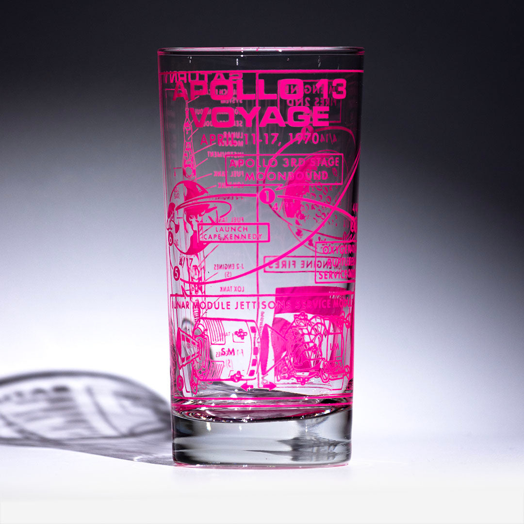 Glass tumbler with pink printed design on a gray background