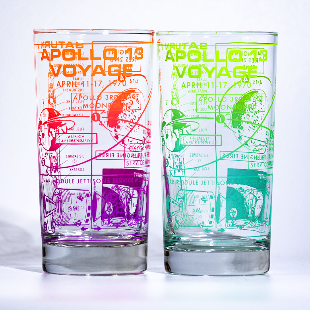 Two glass tumblers with Apollo 13-themed designs on a white background