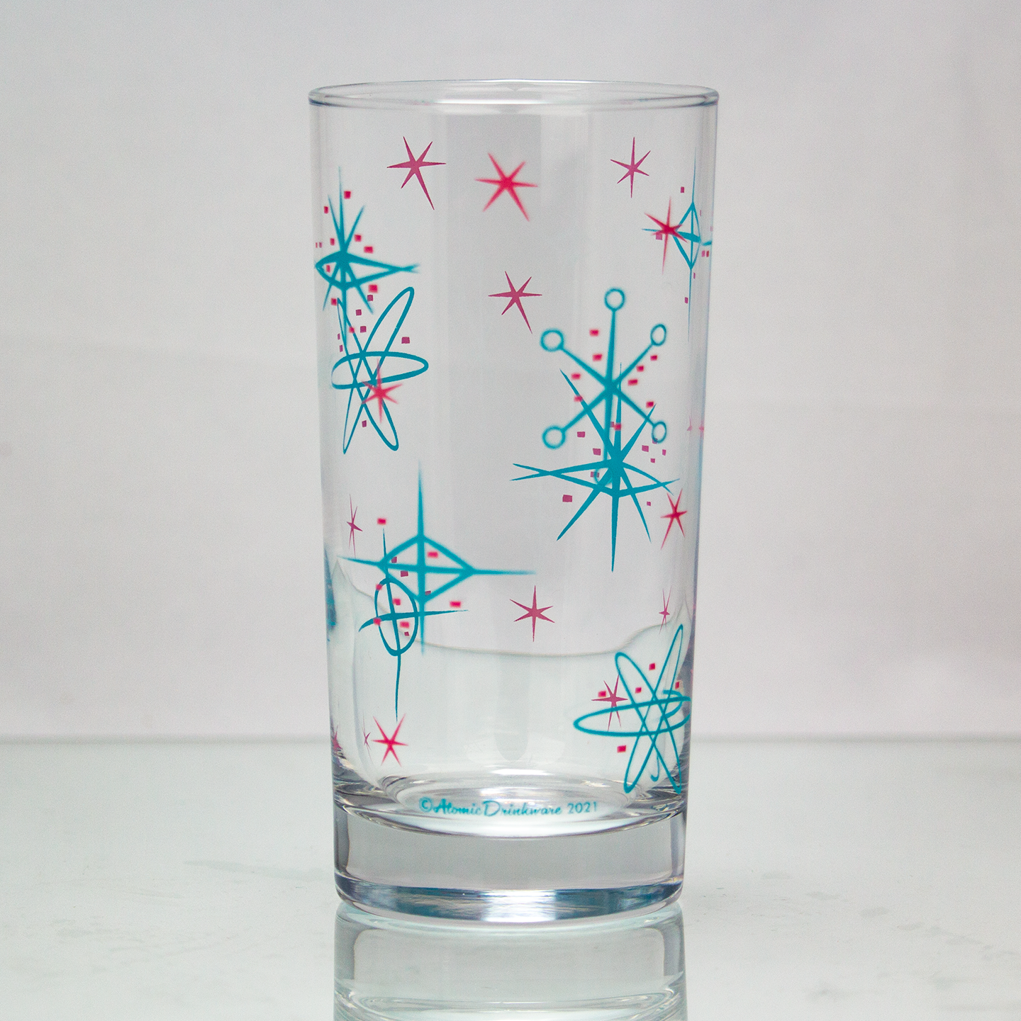Atomic style retro glass with blue and pink starburst patterns on a white background