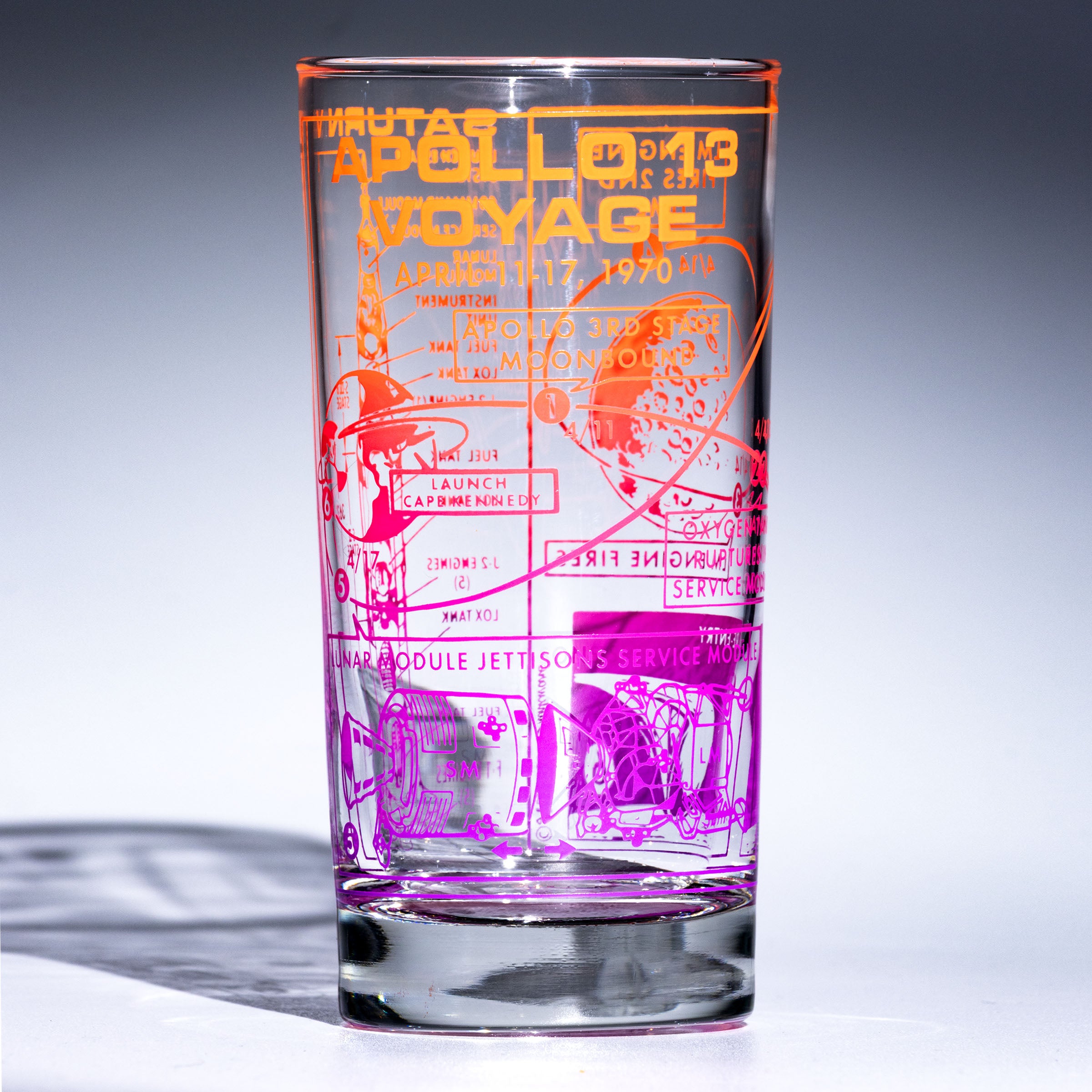 Glass with Apollo 13 decoration in sunset colors on blank background