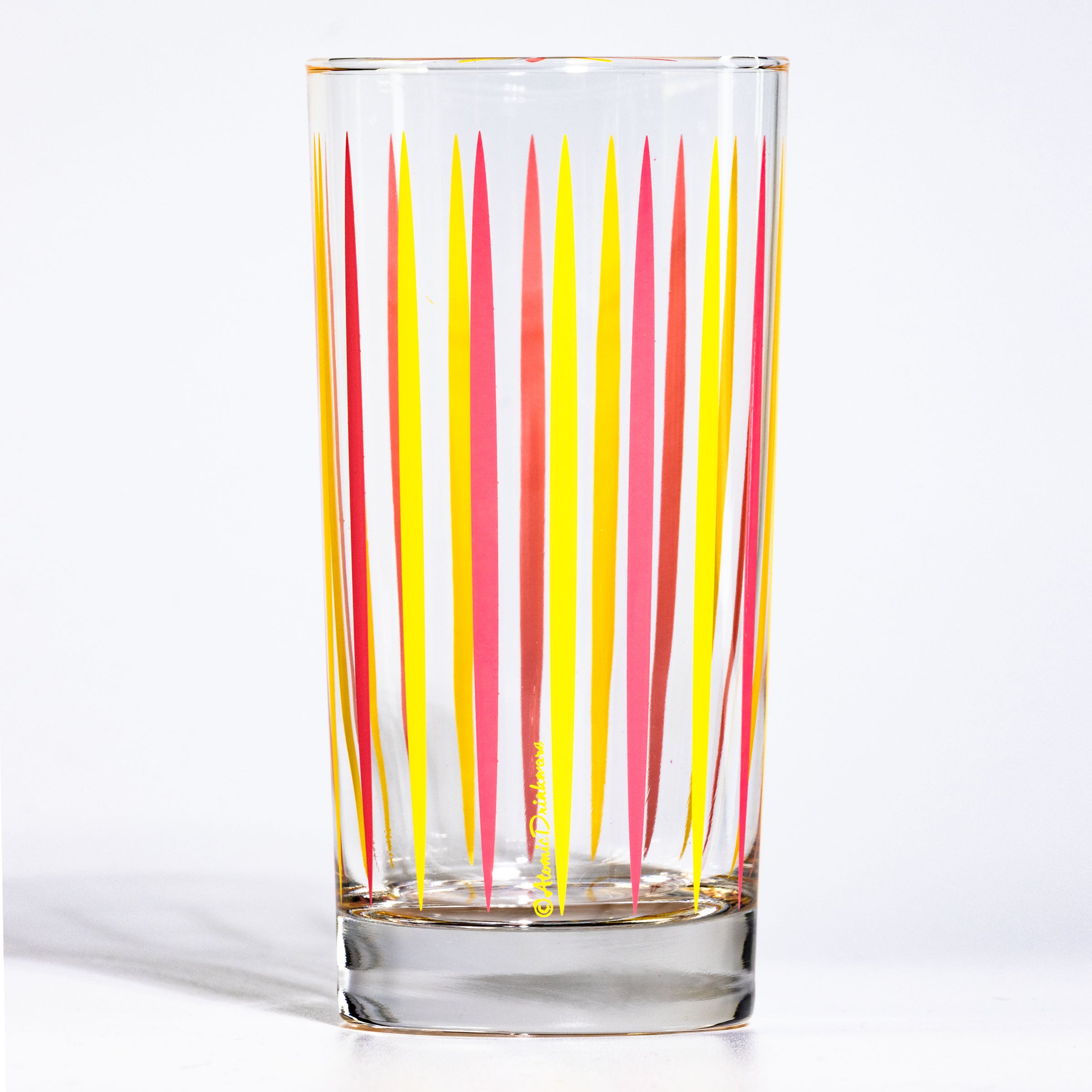 Clear mid century glass with red and yellow vertical stripes on a white background