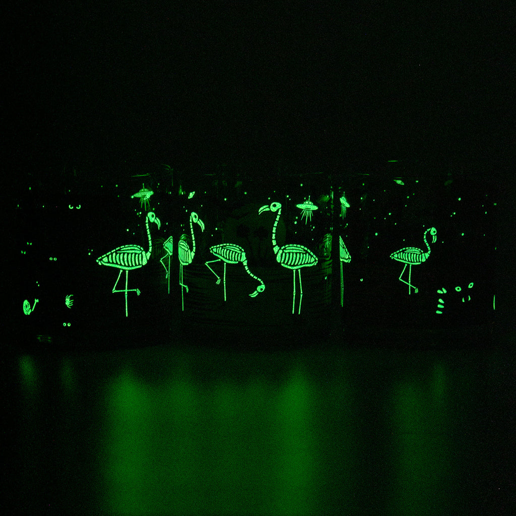 3 Glow in the dark Eerie Everglades Rocks glasses glowing green in the dark to show off the skelemingo illumination. 