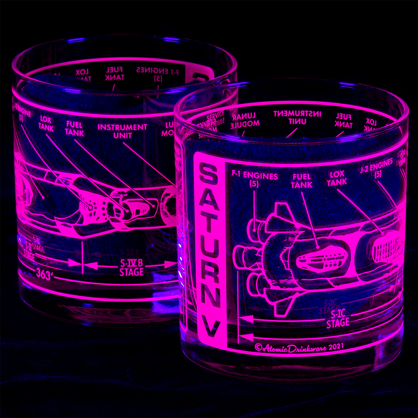 Two glowing purple glasses with technical drawings and 'Saturn V' text on a black background