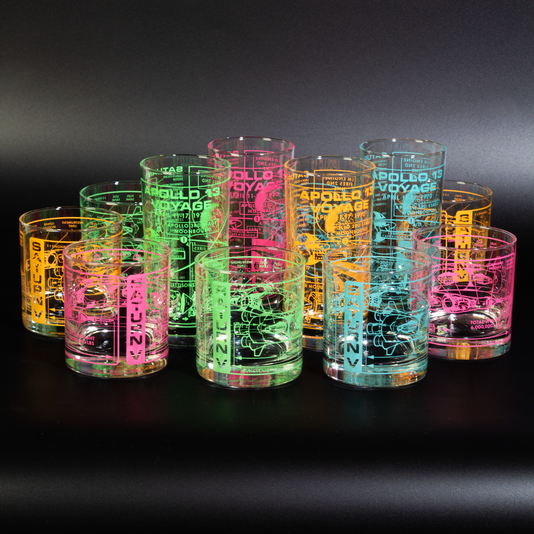 Set of glowing glass tumblers with space design on a black background