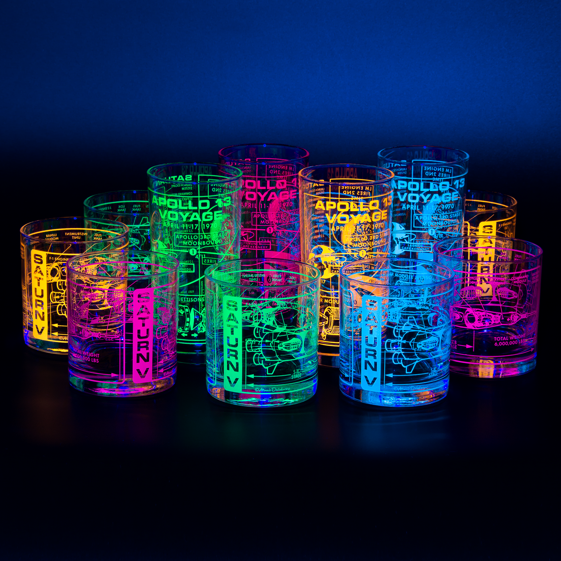 Set of glowing cups with space-themed designs on a dark background