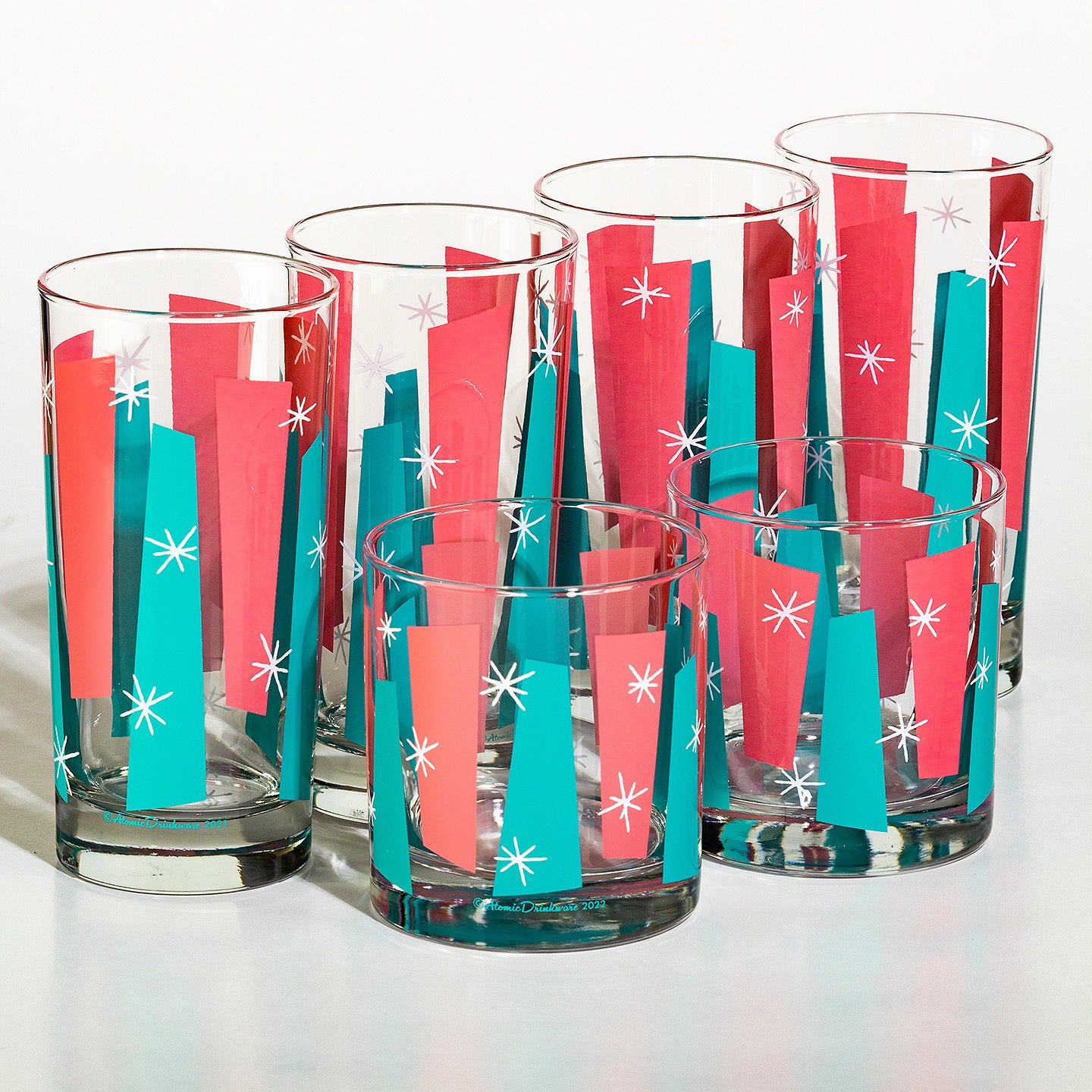 Set of glass tumblers with red and blue mid century geometric pattern on a white background