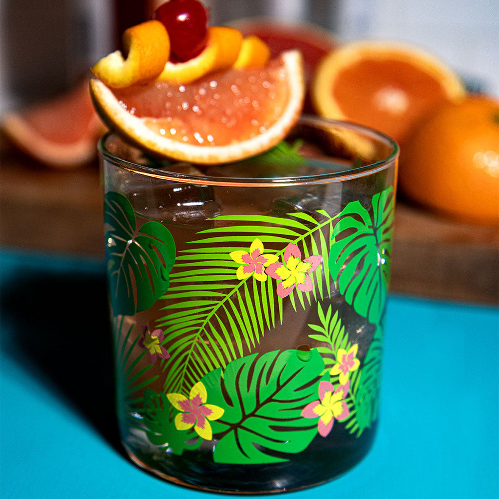 Tropical-themed glass with fruit garnish on a blue surface