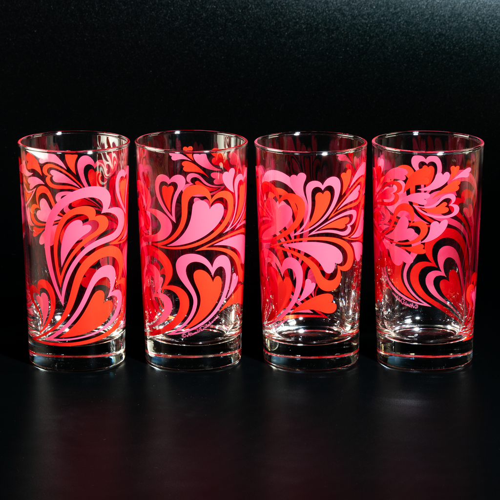 Glass tumbler with pink and red retro heart pattern on a white background