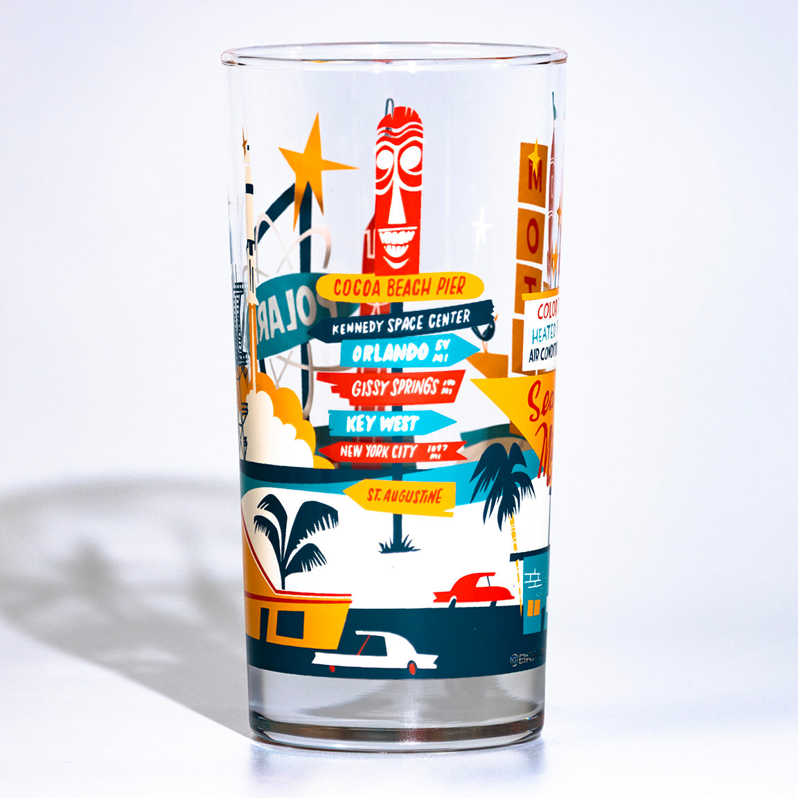 Glass tumbler with colorful travel-themed cocoa beach florida design on a white background