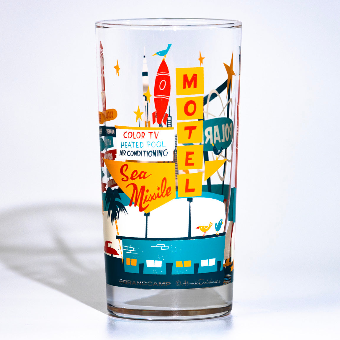 Glass tumbler with retro Sea Missile Motel design on a white background