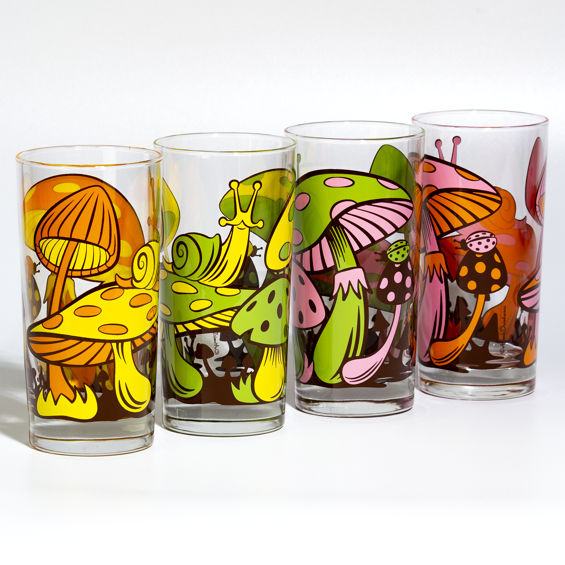 Set of colorful glass tumblers with retro mushroom and abstract designs on a white background