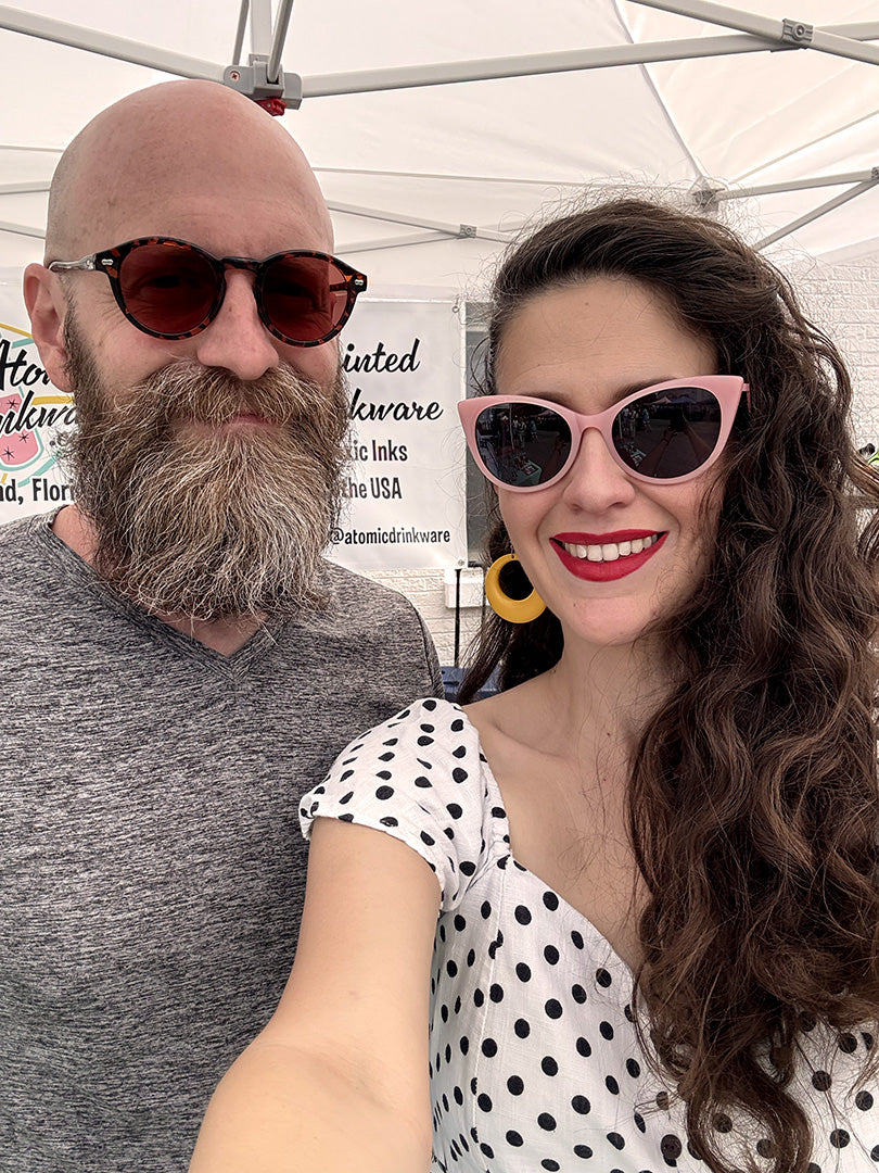 Selfie of Rose and Nick under a white tent at a vendor market