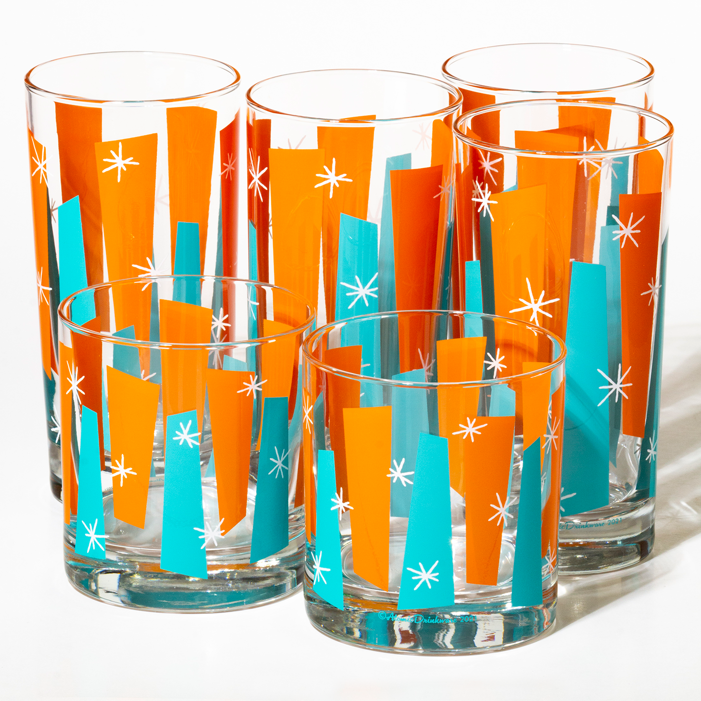 Mid-century modern rocks glass in aqua and orange with white atomic starbursts on Libbey glass
