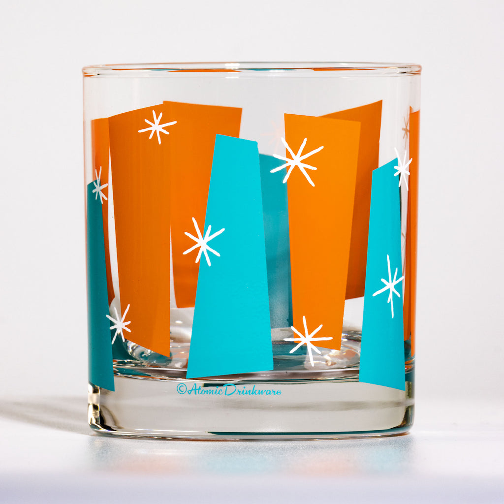 Mid-century modern rocks glass in aqua and orange with white atomic starbursts. Retro Palm Springs style on genuine Libbey glass.