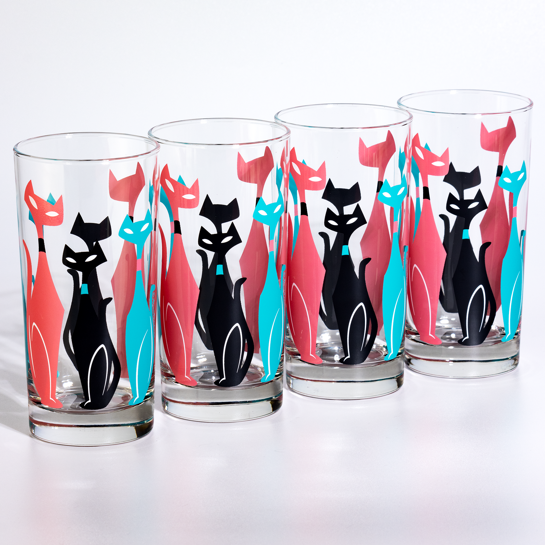 Set of four glasses with retro mid century black cat designs on a white background