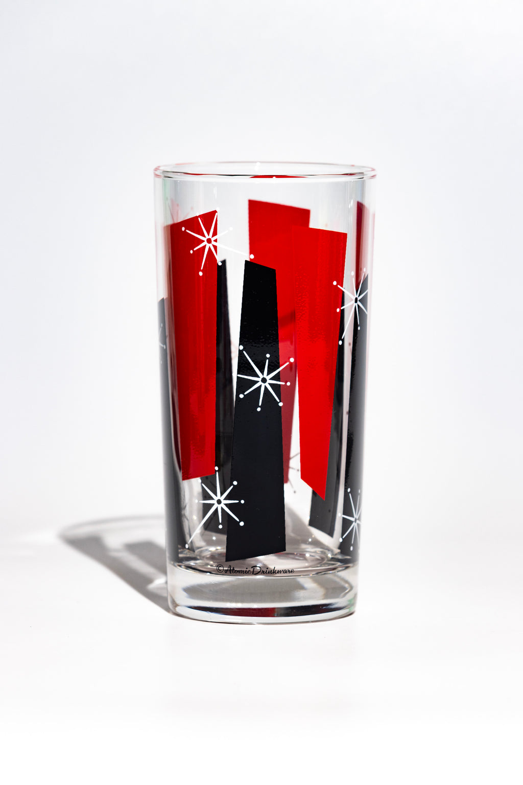 Clear glass with red and black abstract mid century design on a white background