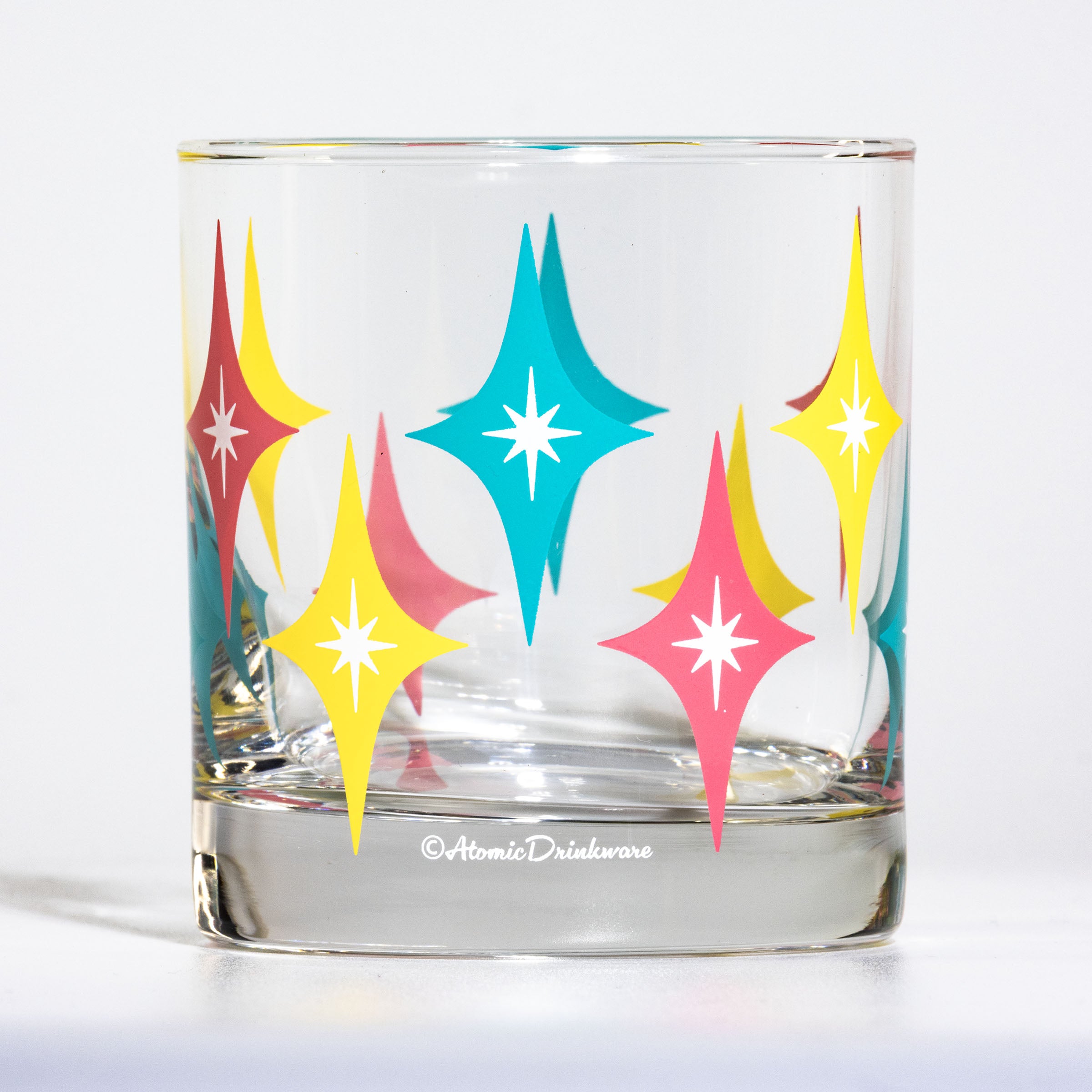 Retro glass tumbler with colorful vintage starburst design for home bar and entertaining