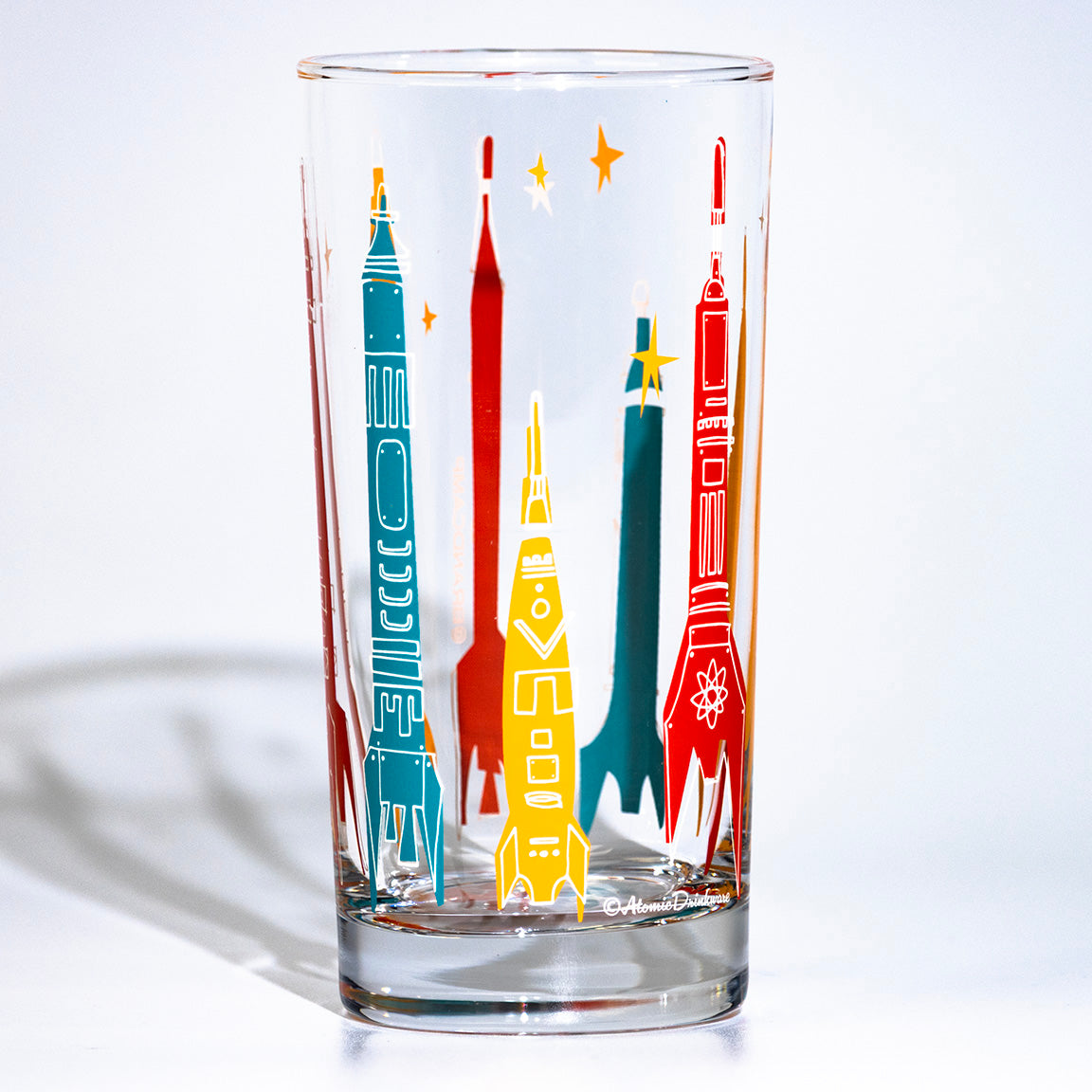 Clear glass with colorful rocket ship designs on a white background
