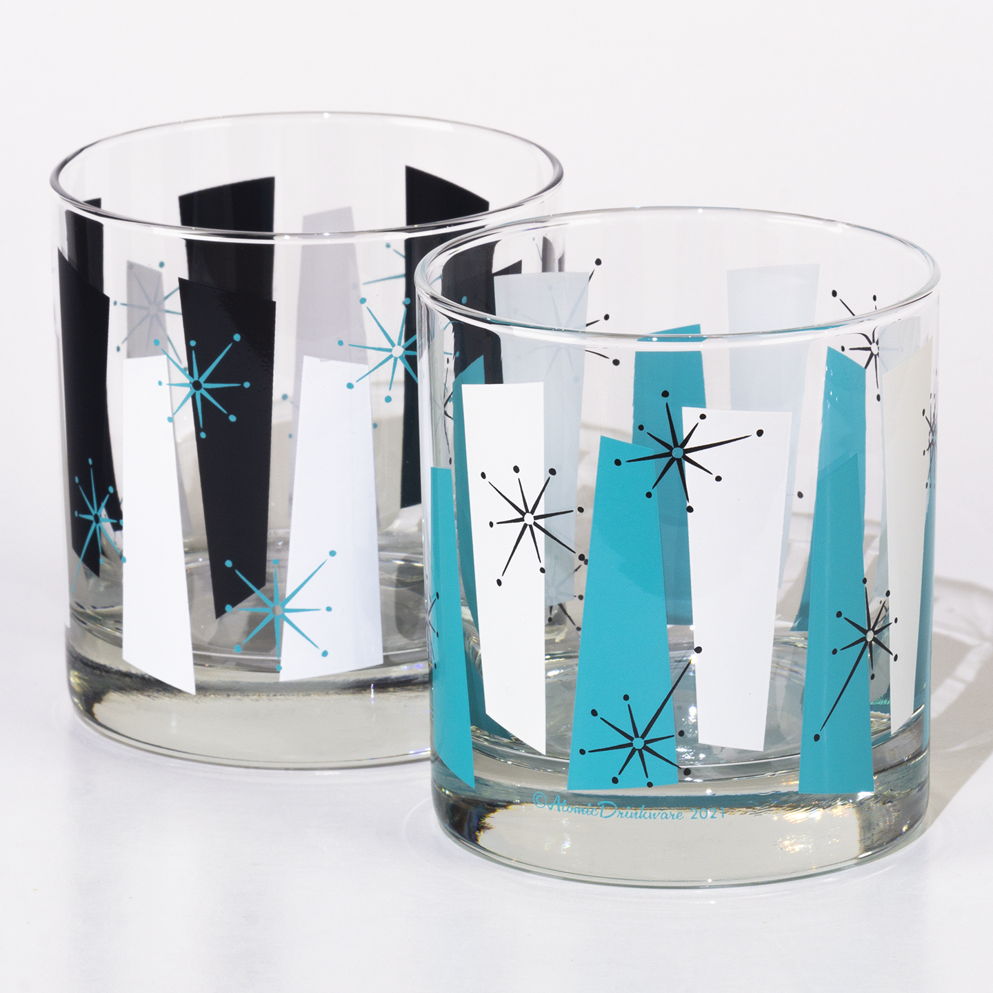Two glass tumblers with retro rock a billy starburst design on a white background