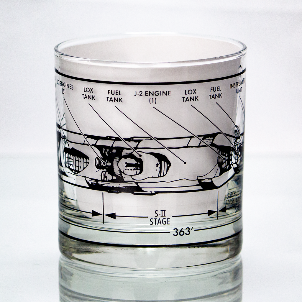 Glass tumbler with rocket engine design etched on it against a white background
