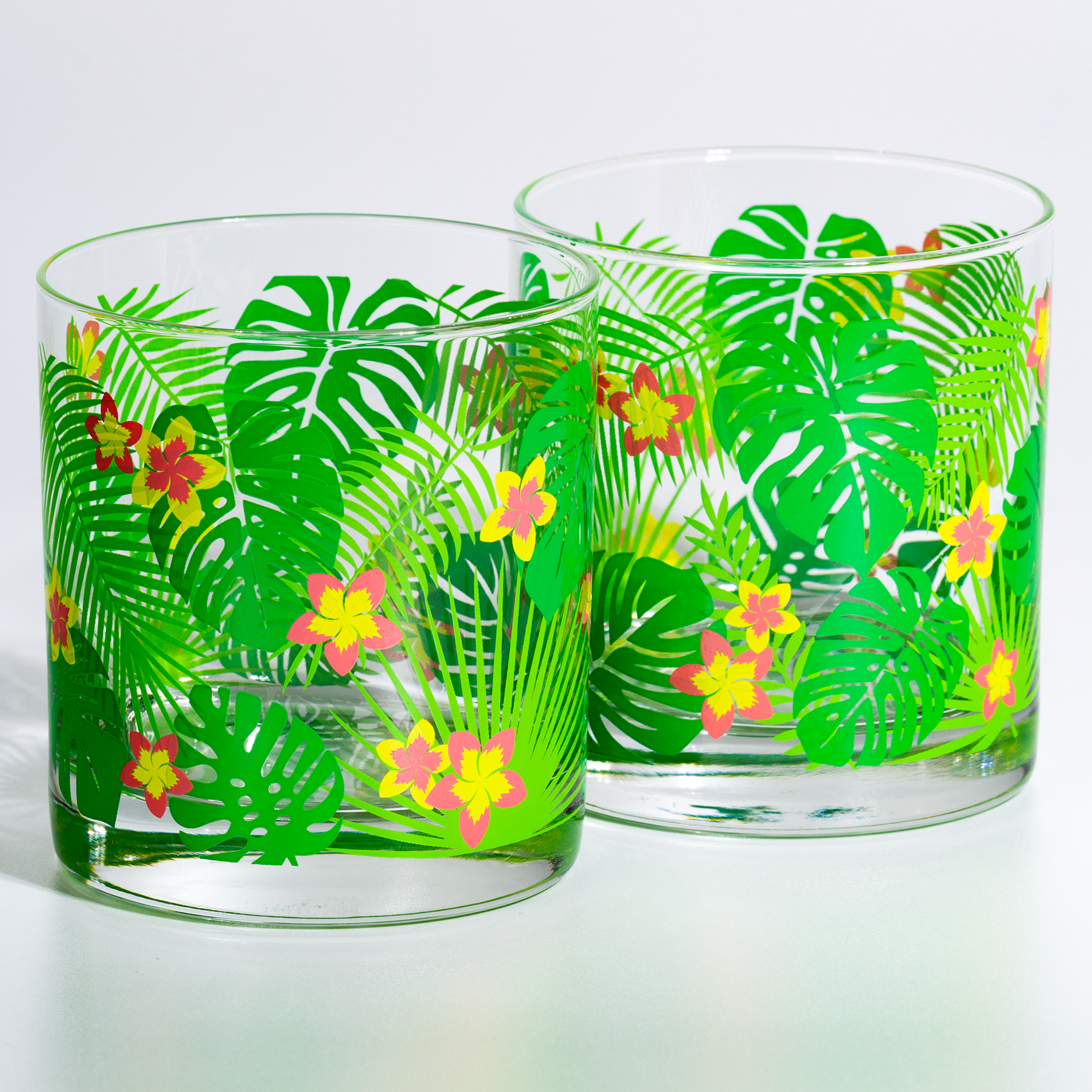 Glass tumbler with vintage retro tropical leaf and flower design for tiki cocktail parties