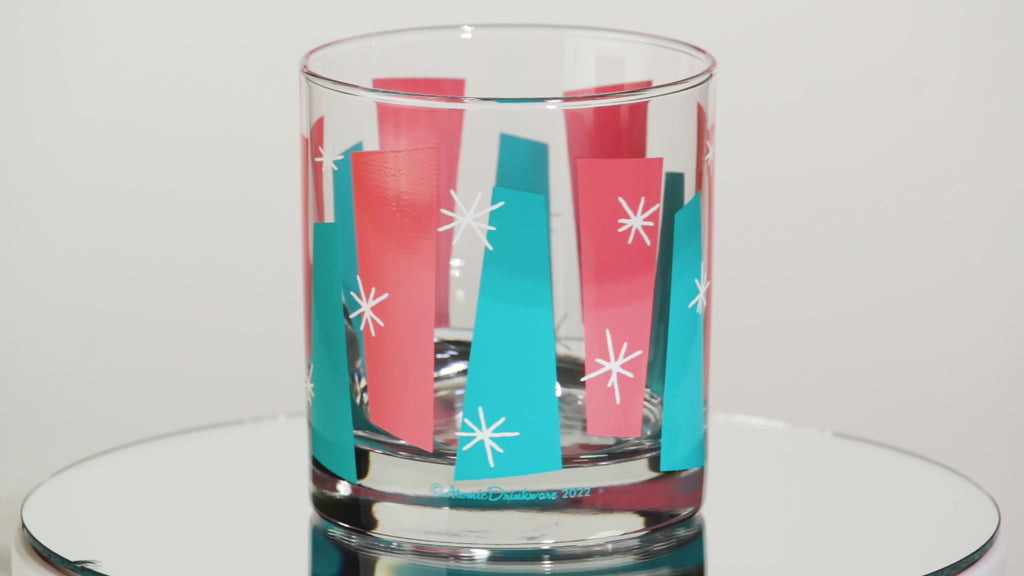 One glass tumblers with colorful retro geometric pattern on a white background