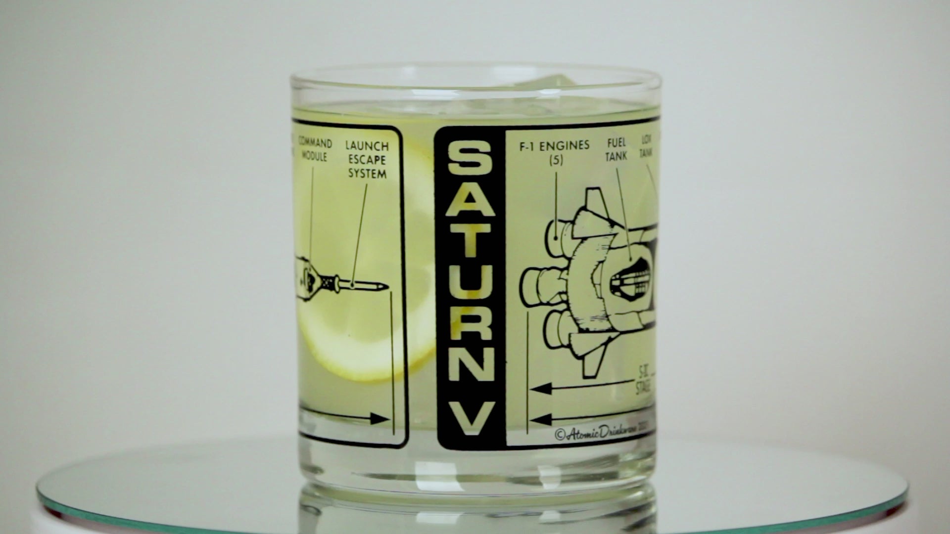 Clear glass with black and white graphic design of Saturn V rocket on a white background