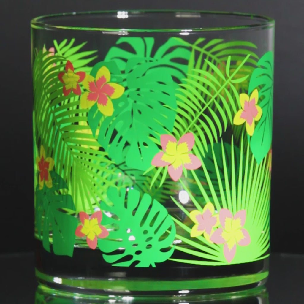 Glass tumbler with vintage retro tropical leaf and flower design for tiki cocktail parties
